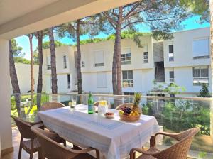 a table with a bowl of fruit on a balcony with a building at White Shell Apartments in Lalzit Bay