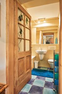 a bathroom with a wooden door and a sink at Buda Hills villa apartment in Budapest