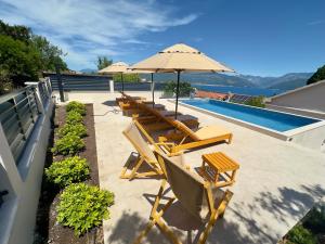 a group of chairs and an umbrella next to a swimming pool at Villa Paula in Radovici +59 photos