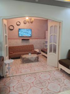 a living room with a couch and a tv on a wall at Oran ville in Oran