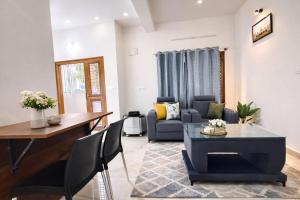 ein Wohnzimmer mit Sofa und Tisch in der Unterkunft Hill View Comforts in Mysore