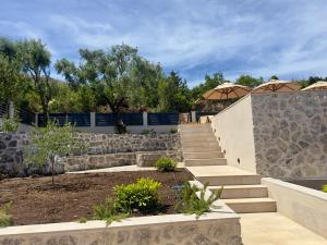 a set of stairs with a stone wall and umbrella at Villa Paula in Radovici