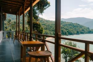 a porch with chairs and a view of the water at Legon Waru Cottage in Karimunjawa