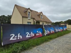 a fence in front of a house next to a house at Chambres Logement 130m2 - Circuit 24h Le Mans in Arnage