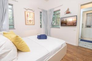 a white bedroom with a bed and windows at Me & U - הווילה שלי בכנרת in Tel Kazir