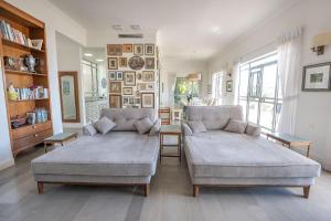 a living room with two couches and a books shelf at Me & U - הווילה שלי בכנרת in Tel Kazir
