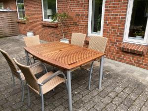 a wooden table and chairs in front of a brick building at Lille hus i Sydbyen in Silkeborg +33 photos