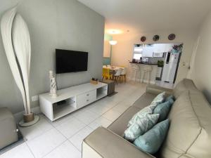 a living room with a couch and a flat screen tv at Apartamento Riviera Ilha da Madeira in Riviera de São Lourenço