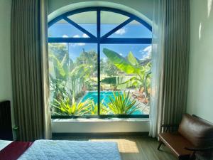 a bedroom with a large window with a view of a pool at Mountain view Homestay in Ninh Binh