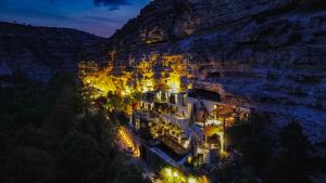 a building on the side of a cliff at night at XUQ Hotels Lomas de Ruvira in Jorquera