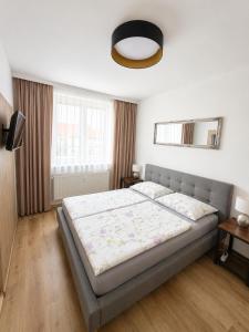 a bedroom with a bed and a large window at Apartmány U Jelena 2 in Český Krumlov +4 photos