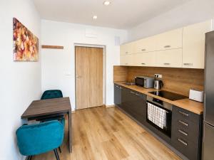 a kitchen with a table and a blue chair at Apartmány U Jelena 2 in Český Krumlov