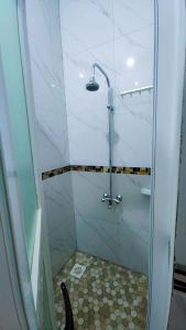 a shower with a glass door in a bathroom at Zone hotel and guest house in Bugembe