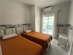 two beds in a room with a window at Apartamento Riviera Ilha da Madeira in Riviera de São Lourenço +31 photos