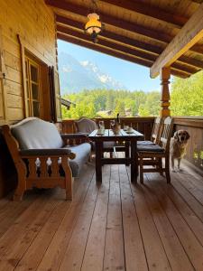 a porch with a table and chairs and a dog at Chalet Zugspitze in Grainau