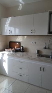 a kitchen with white cabinets and a sink at Andalus Sunset in Tangier