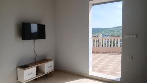 a room with a tv on a wall with a window at Andalus Sunset in Tangier