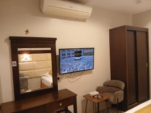 a room with a bedroom with a mirror and a chair at شقق نزل التوت للشقق المخدومة in Al Kharj