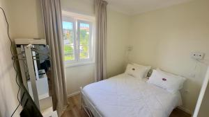 a small bed in a room with a window at Pink-Shell in Santiago de Riba-Ul