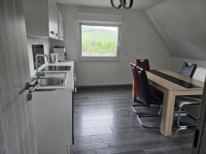 a kitchen with a wooden table and a table and chairs at RUHIGE Eke in Netphen