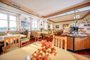 a restaurant with tables and chairs and windows at Birkenhof Loipersdorf in Loipersdorf bei Fürstenfeld