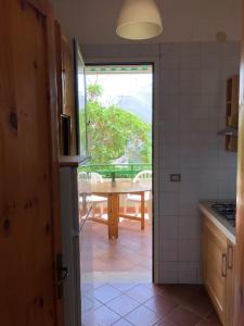 a kitchen with a view of a table and a window at Oasi Baia Verde in Baia Verde +4 photos
