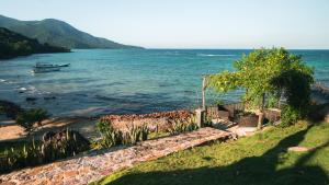a boat in the water next to a beach at Legon Waru Cottage in Karimunjawa +5 photos