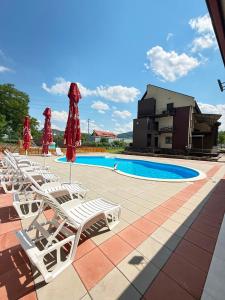 a row of lounge chairs next to a swimming pool at Vila Premiere Bistro-Spa in Piatra Neamţ