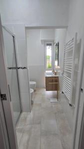 a white bathroom with a toilet and a sink at B&B House Novara in Novara