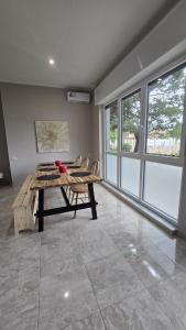 a room with a wooden table and chairs and windows at B&B House Novara in Novara