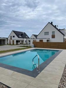 a large swimming pool in front of a house at Ferienhaus Lilja mit Grill Kamin eignes großes Grundstück und Außenpool in Trzęsacz