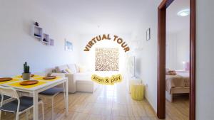 a white living room with a table and a couch at Primavera apartment with heated pool in Palm-Mar