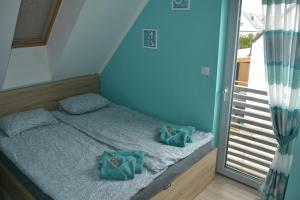 a bedroom with a bed with green pillows on it at Ferienhaus Lilja mit Grill Kamin eignes großes Grundstück und Außenpool in Trzęsacz