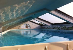 a swimming pool in a house with a roof at Palazzo Turro Bed & Breakfast in Podenzano