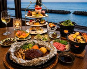 a table with many plates of food and drinks at 館山 New WestPeninsula Hotel ニューウエストペニンシュラホテル in Tateyama