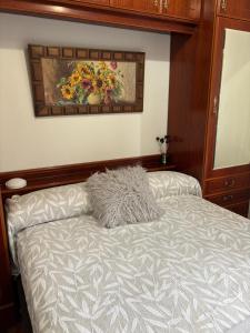 a bed in a bedroom with a painting on the wall at Libarona Goya in Gatica