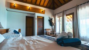 a bedroom with a large bed with towels on it at Legon Waru Cottage in Karimunjawa