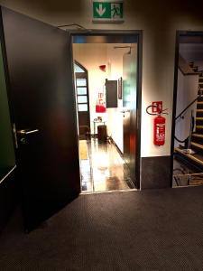 an open door to a room with a fire extinguisher at Sleephotels Suite Garde in Hamburg
