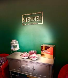 a table with three bowls on top of a green wall at Sleephotels Suite Garde in Hamburg