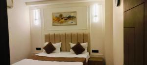a bedroom with a bed and a picture on the wall at hotel elite inn in Greater Noida