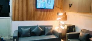 a living room with a couch and a television at hotel elite inn in Greater Noida