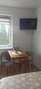 a dining room with a table and chairs and a window at Wzgórze za miedzą - Niezależne Studio z osobnym wejściem in Sicienko