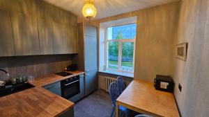 a kitchen with a table and a sink and a window at Keskallee Charm in Kohtla-Järve
