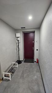 an empty hallway with a red door and a red door at Keskallee Charm in Kohtla-Järve
