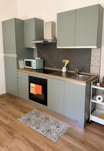 a kitchen with a sink and a microwave at Su Entu Suite Free Parking 5 min from the sea in Giba +10 photos