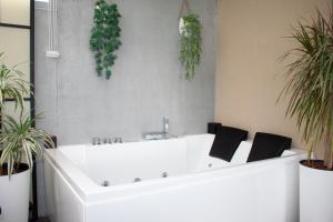 a white bath tub with plants on a wall at Luxury by the Blue in Vila Nova de Gaia +22 photos