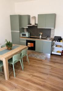 a kitchen with a wooden table and chairs in a kitchen at Su Entu Suite Free Parking 5 min from the sea in Giba