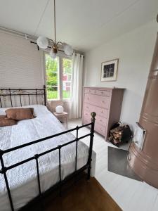 a bedroom with a bed and a dresser and a window at Vääksyn Mummola in Vääksy