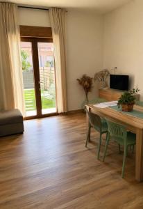 a living room with a wooden table and chairs at Su Entu Suite Free Parking 5 min from the sea in Giba