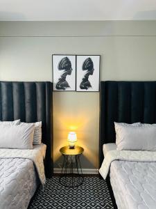 a bedroom with two beds and a table with a lamp at Home By The Sea in Gqeberha